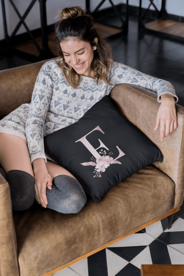 Custom Printed Monogram Letter E on Black Pillow Case pillow mockup of a smiling girl sitting on a sofa