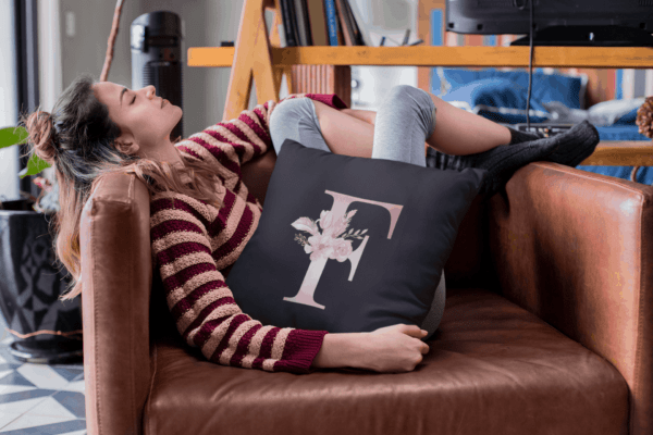 Custom Printed Monogram Letter F on Black Pillow Case mockup of a woman relaxing on her couch