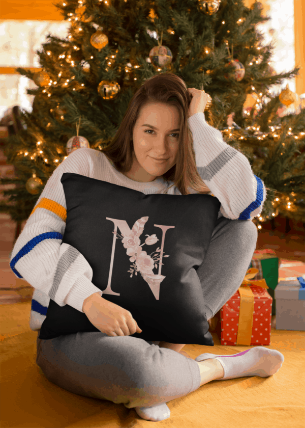 Custom Printed Monogram Letter N on Black Pillow Case square pillow mockup featuring a girl under a christmas tree