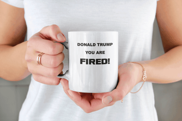 Donald Trump You Are Fired Custom Printed Mug mockup of a woman holding an 11-oz coffee mug