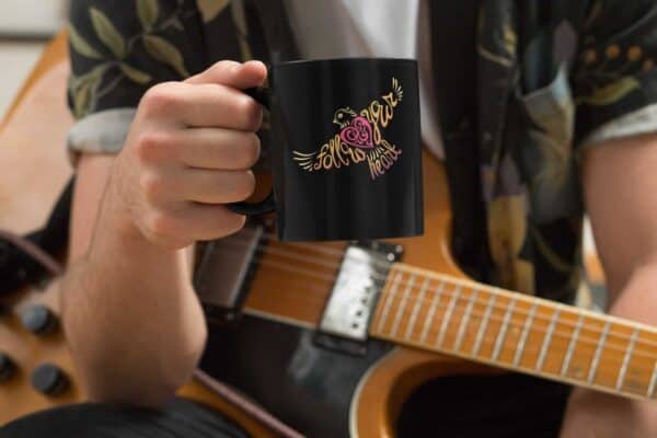 Follow Your Heart Coffee Mug Design Black mockup of a musician holding an 11oz coffee mug