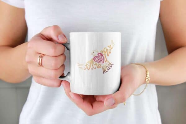 Follow Your Heart Coffee Mug Design White mockup of a woman holding an 11 oz coffee mug