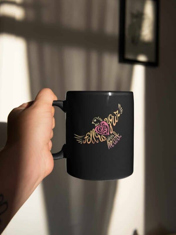 Follow Your Heart Coffee Mug Design on Black sticker mockup featuring a man holding a coffee mug