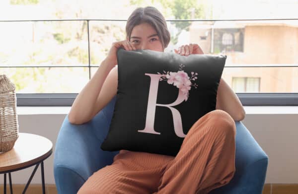 Custom Printed Monogram Letter R on Black Pillow Case mockup featuring a woman hiding a pillow in front of her-face