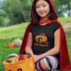 Girl sitting in the grass in Halloween T-shirt