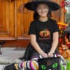 Girl sitting in front of a door in Halloween costume